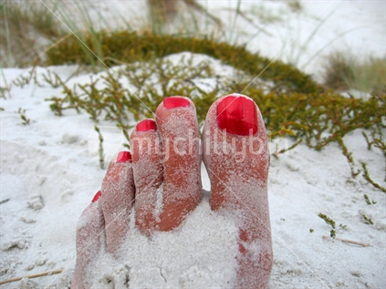 Painted toenails in the sand