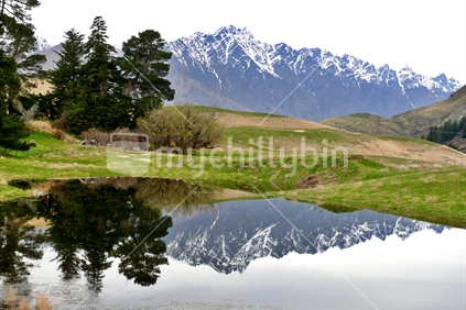 The Remarkables reflected in small lake, Queenstown, South Island, New Zealand