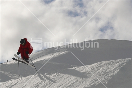 Skier leaping off slope