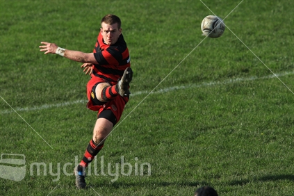 A rugby player kicks during a rugby game in Wellington.