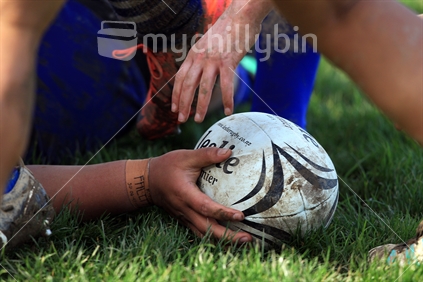 A rugby player presents the ball during a women''s rugby game in Wellington.