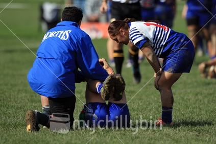 A rugby player checks on an injured teammate during a women's rugby game in Wellington.
