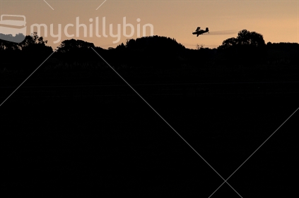 A top-dressing plane flies over farmland in Manawatu.