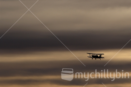 A top dressing bi plane plane flies over farmland in Manawatu.