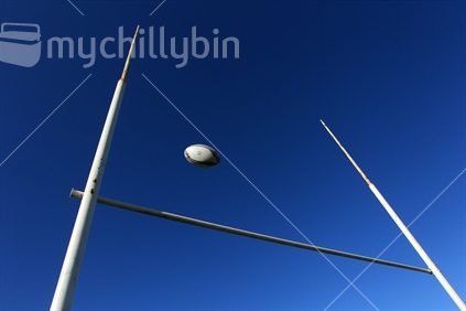A rugby ball passing through goalposts.