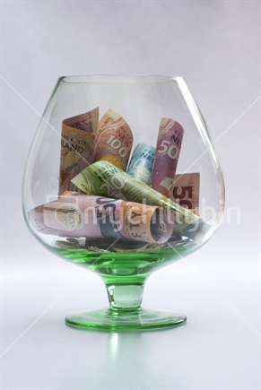 New Zealand currency in big glass