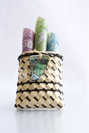 New Zealand currency in little flax bag with paua shell decoration
