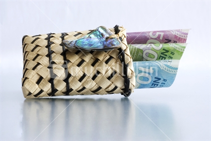 New Zealand currency in little flax bag with paua shell decoration
