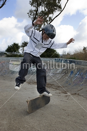 Young boy practicing skateboard tricks
