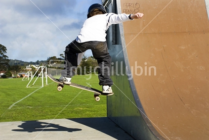 Skateboarder airborne jumping off ramp