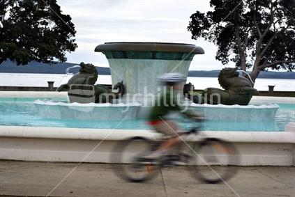 Cyclist rushing past the water fountain at Mission Bay, Auckland