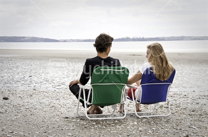 Young couple in beach chairs