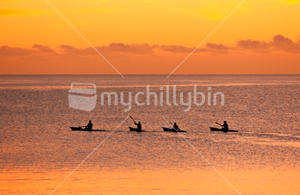 Four sea kayakers at sunrise, New Zealand