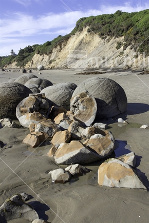 Moeraki Boulders with one boulder cracked open to reveal its inside colours
