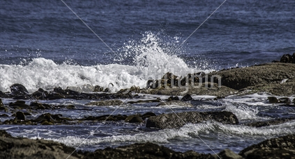 waves crashing onto rocks and kelp