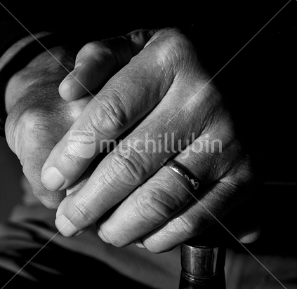 Hands leaning on a walking stick