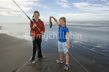 Two kids fishing at mouth of Waimakariri River, Kairaki, New Zealand