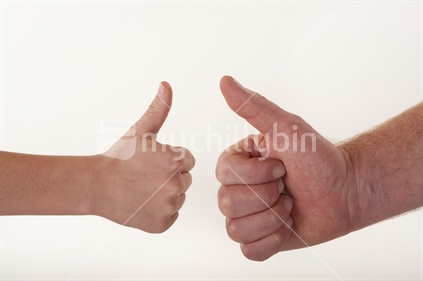 Hand shot of boy and man hands doing thumbs up against white background