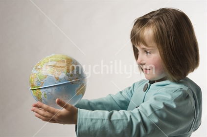 Little girl looking at globe