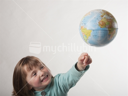 Little girl trying to touch a just out of reach world