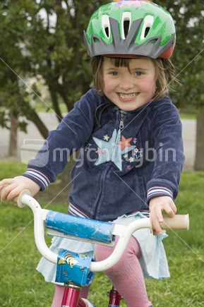 4 year old girl learning to ride push bike with training wheels