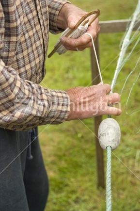 Elderly man making fishing net