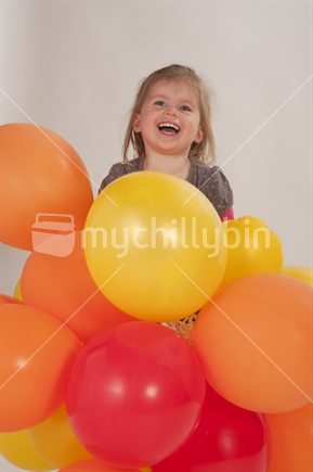 Little girl excited and happy playingwith colourful balloons