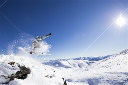 Snowboarder airborne over the southern alps