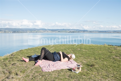 young woman relaxing on blanket with scenic backdrop
