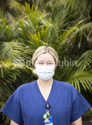 Young woman nurse in uniform with a protective mask