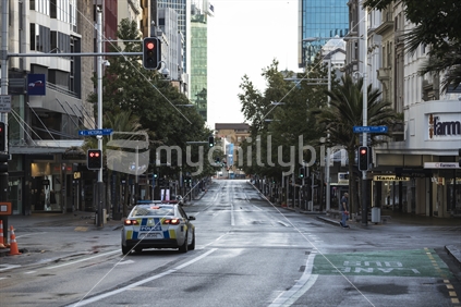 Police patrol empty Queen Street during New Zealand pandemic
