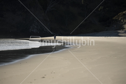 Person running along empty beach