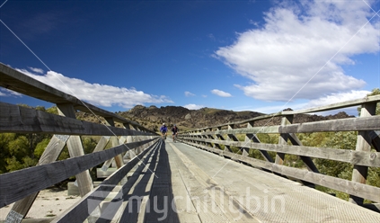 Cyclists on bridge on Otago Rail Trail, New Zealand.