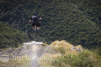 Mountain biker hitting jump near Mt Hutt bike park