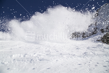 A snowboarder sprays snow