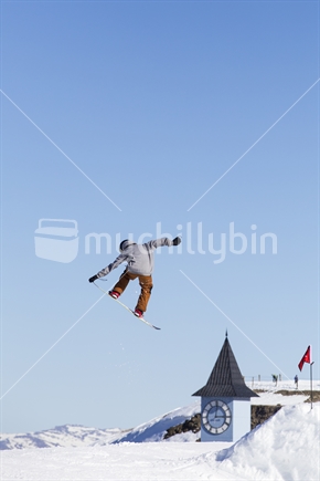 Snowboarder jumping at ski area
