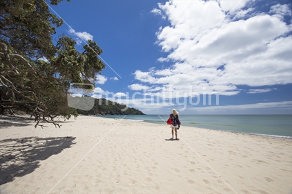 Female walking on Orokawa beach, Waihi, Coromandel