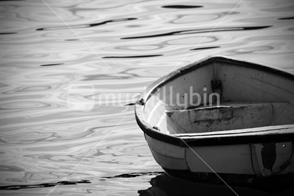 Wooden dinghy rocks peacefully in the calm waters of Akaroa