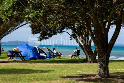 Holidaymakers enjoying the Orewa beach and settled in for the kiwi summer day