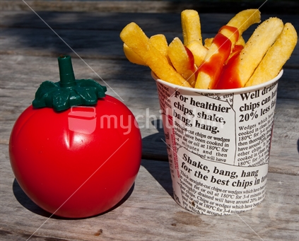Hot Chips in a container next to a Tomato shaped Tomato Sauce Container