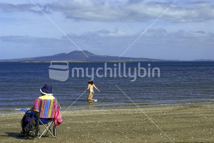 Swimmer and spectator with Rangitoto Island in background