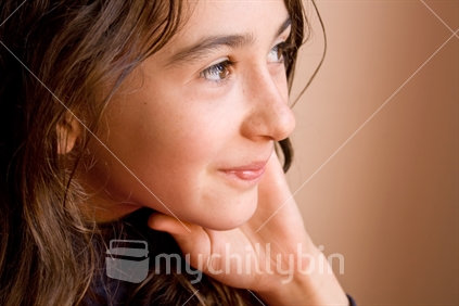 Girl resting chin in hand, looking right