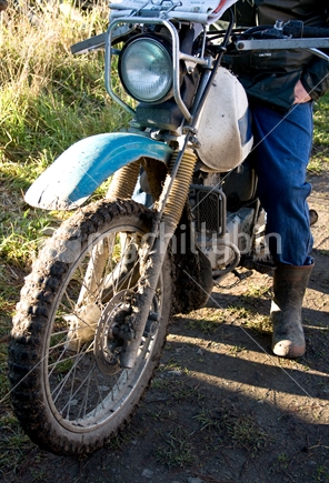 Motorbike, with rider, on a farm