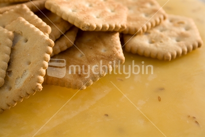 Crackers piled atop a waxed cheese 