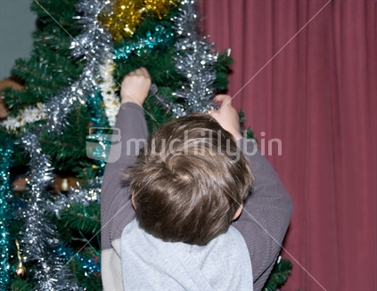 Young boy decorating the Christmas tree