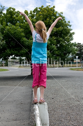 Girl balancing on a low railing