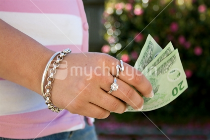 Female hand with $20 notes, New Zealand