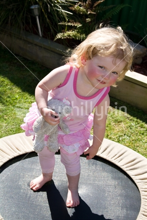Cute two-year-old New Zealand girl on mini-trampoline 