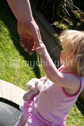 Girl toddler holding father's hand