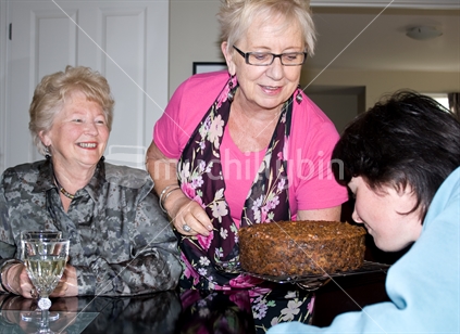 Three women checking out the freshly baked Christmas cake.